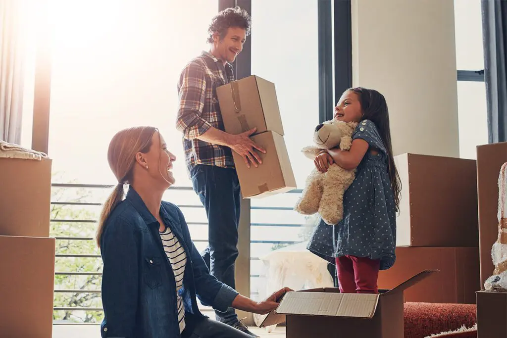 Family of three unpacking moving boxes