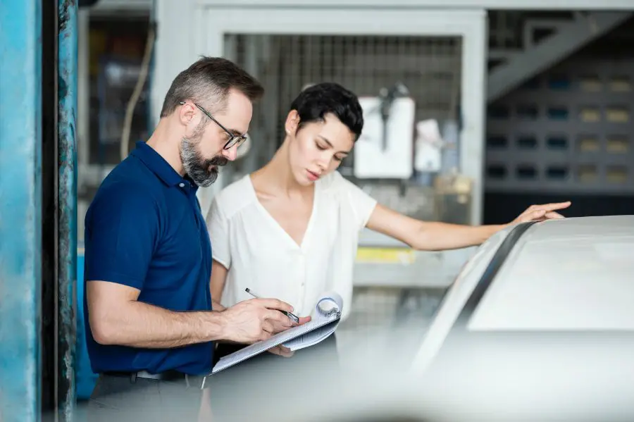man-and-woman-inspecting-car-damage
