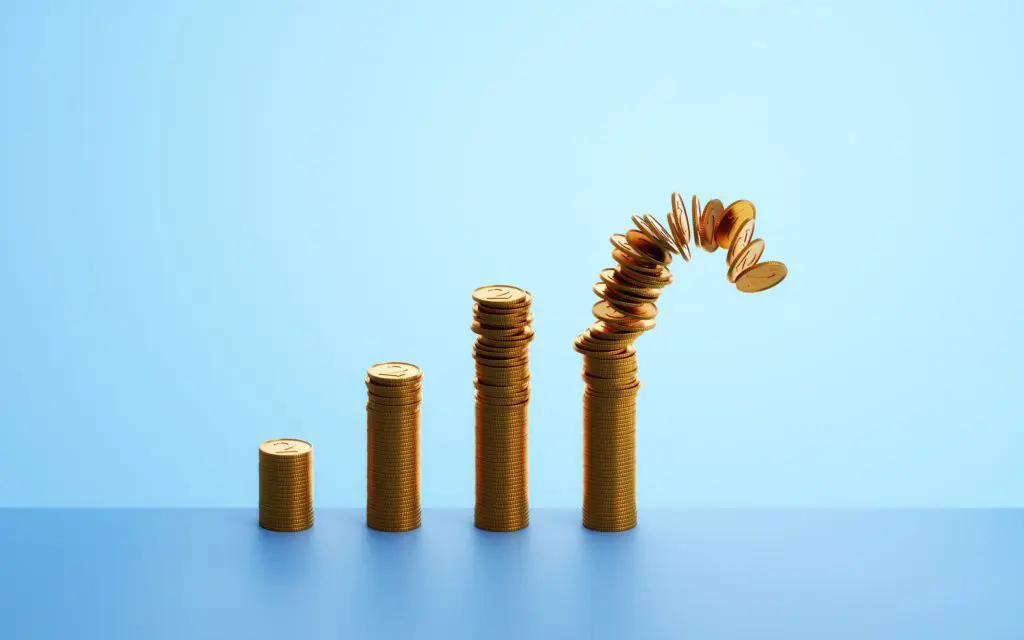 Four stacks of coins growing from shorter to taller, the tallest one is being knocked over