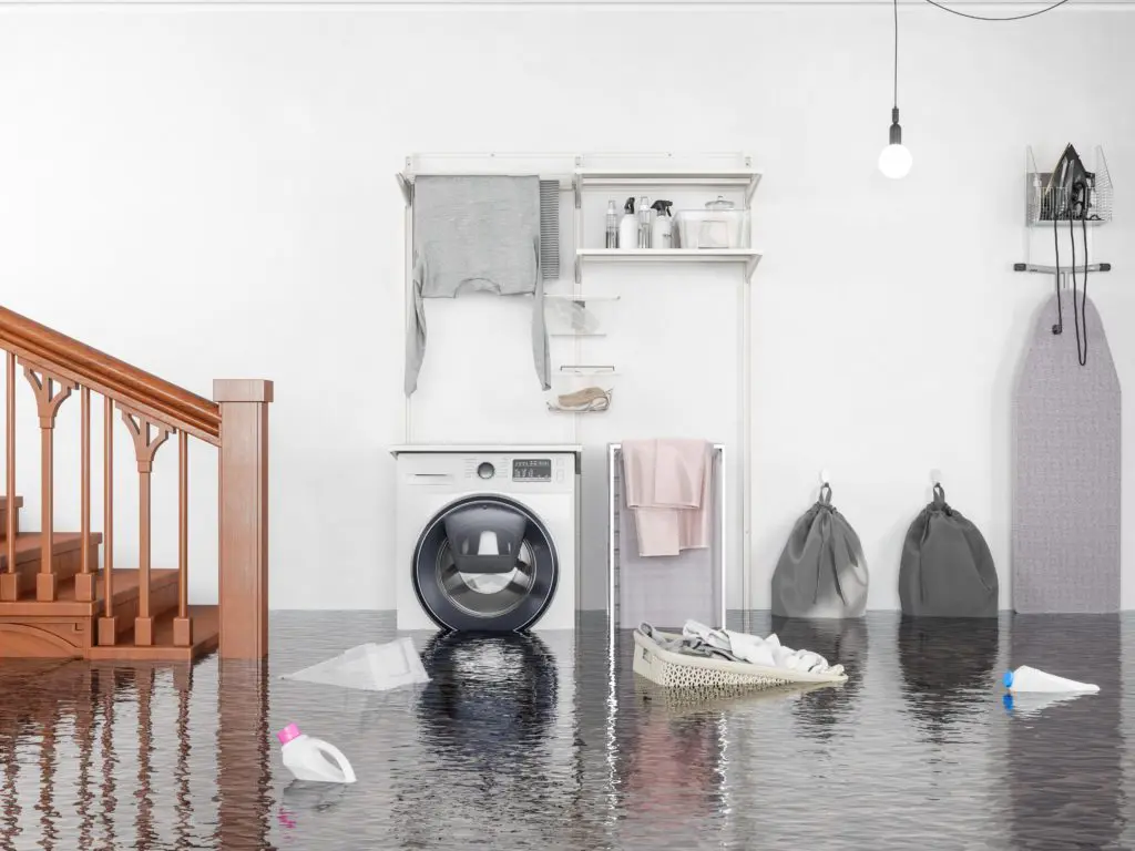 Flooded home laundry room with baskets and clothing floating in the water