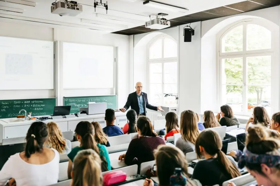 A university professor addressing his pupils during a lecture in a bright, modern lecture theatre.