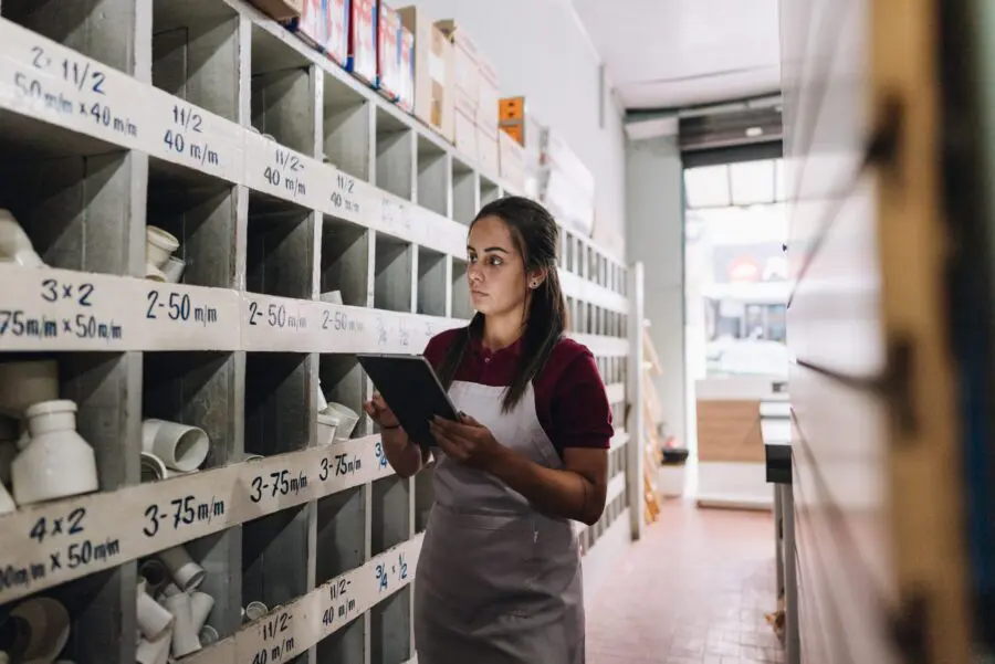 Young woman working at stock of building material store