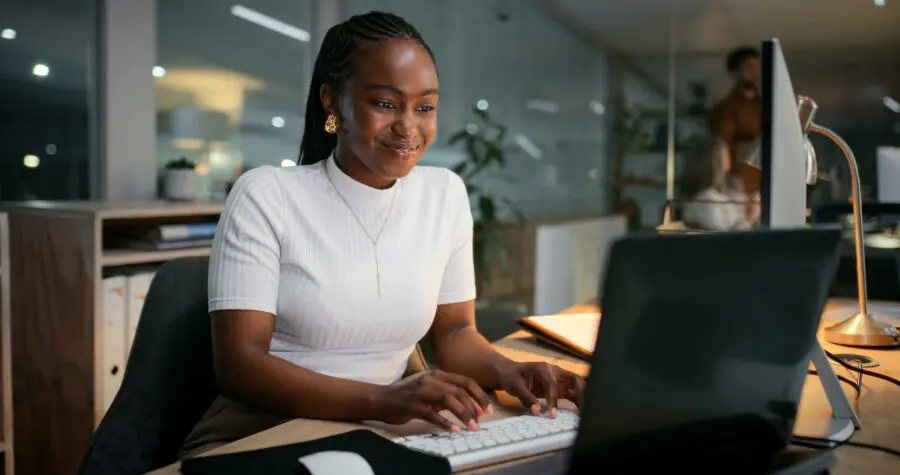 Night, Woman And Computer In Office For Finance, Positive Feedback And Report Deadline. Happy Accountant, Tech And Typing In Agency For Economy Growth, Investment Research Or Email Networking In Dark