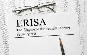 ERISA papers on a desk with pencil and eye glasses