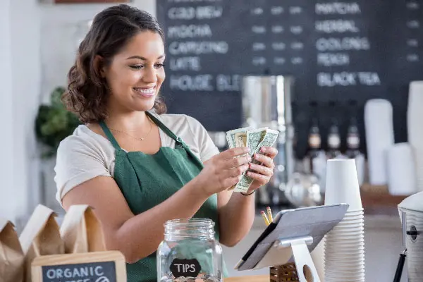 Waitress counting tips from tip jar