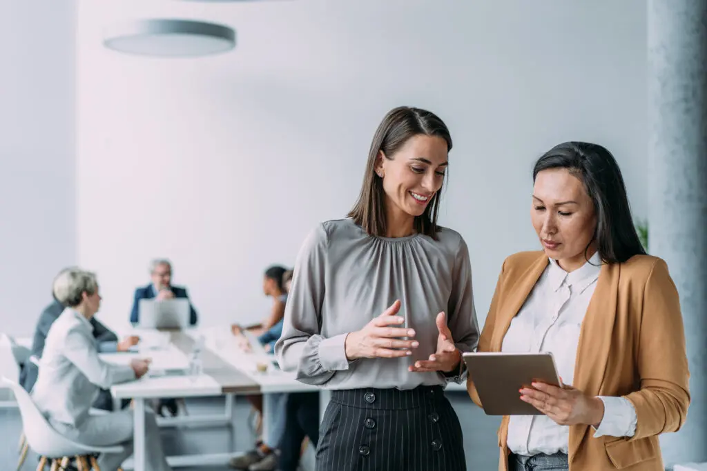 Shot of two female coworkers having a professional discussion in modern office