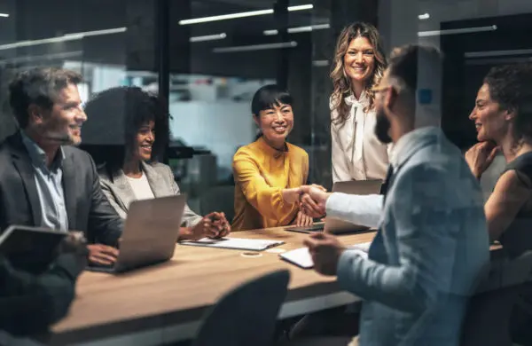 Group of business people shaking hands during a team meeting in board room