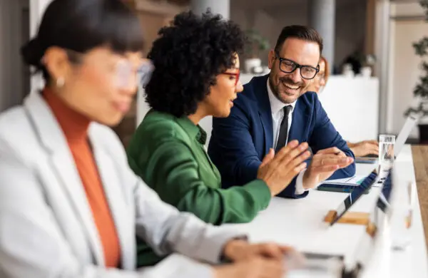 A group of coworkers discussing ideas in a modern office setting