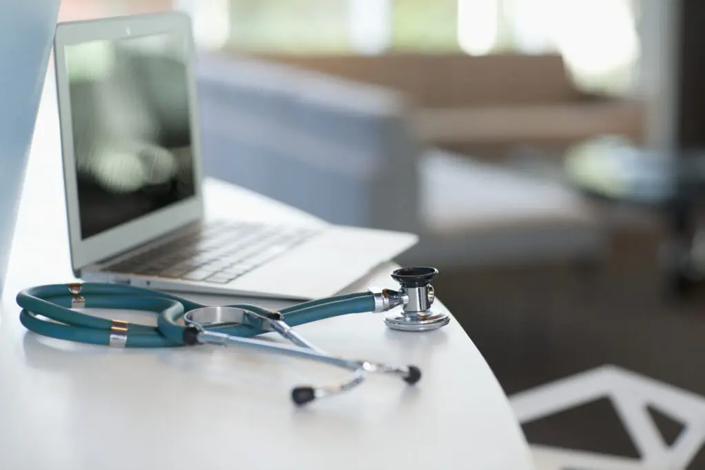 Laptop and stethoscope on the desk of health care provider in a hospital setting