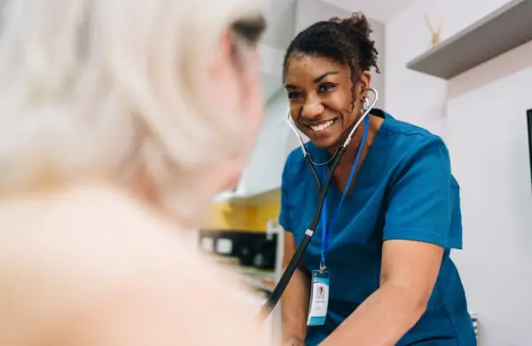 Nurse taking blood pressure of a patient at home