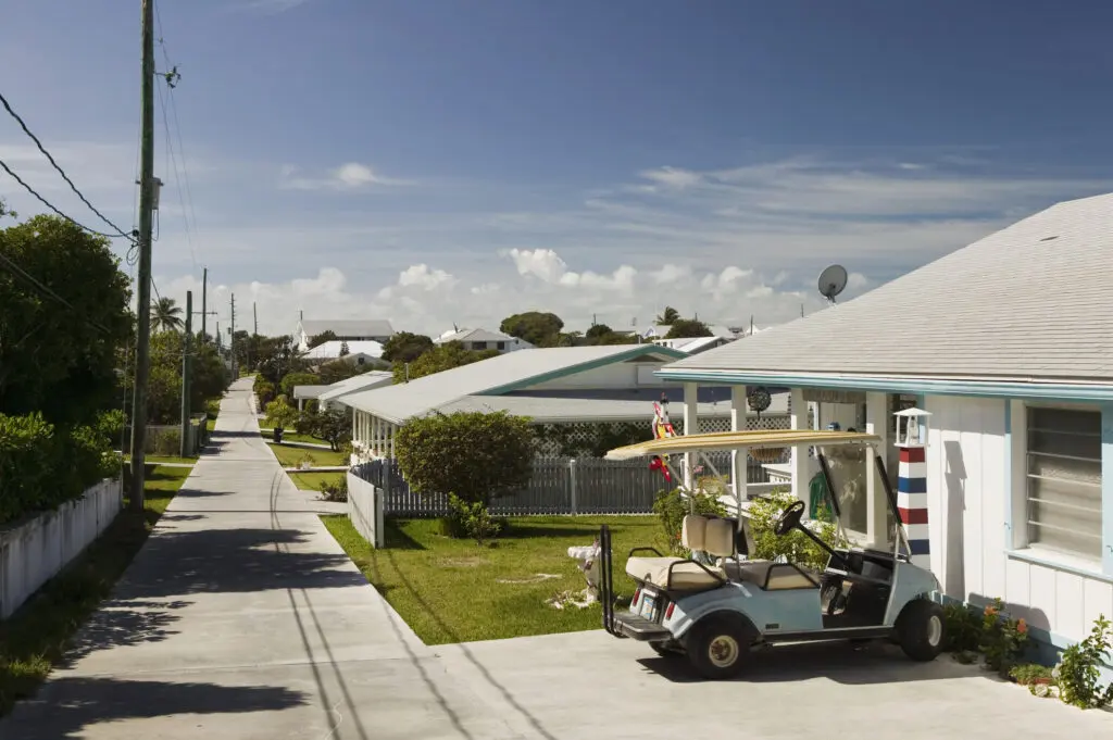 Golf cart parked in front of a house in a coastal residential neighborhood