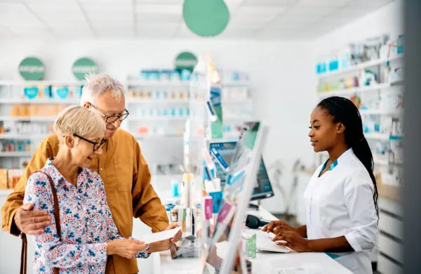 An elderly couple looking at a prescription at the pharmacy counter