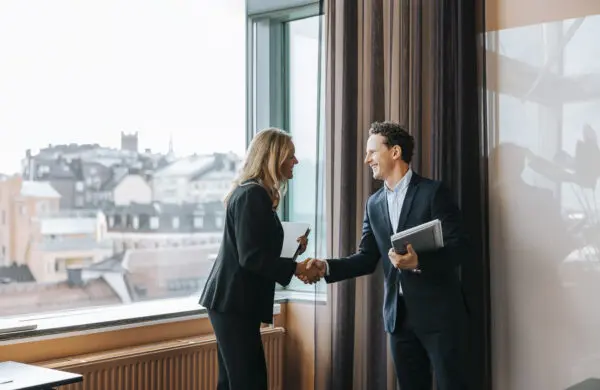 Happy male and female business professionals doing a handshake at office
