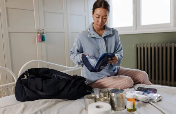 Woman packing a household emergency bag with essential items