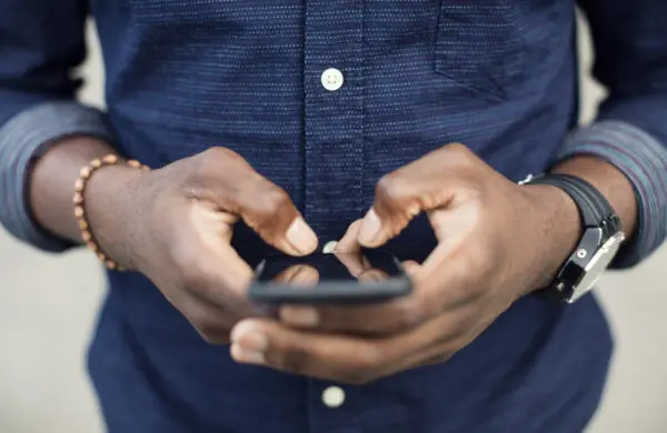 Midsection of man using mobile phone