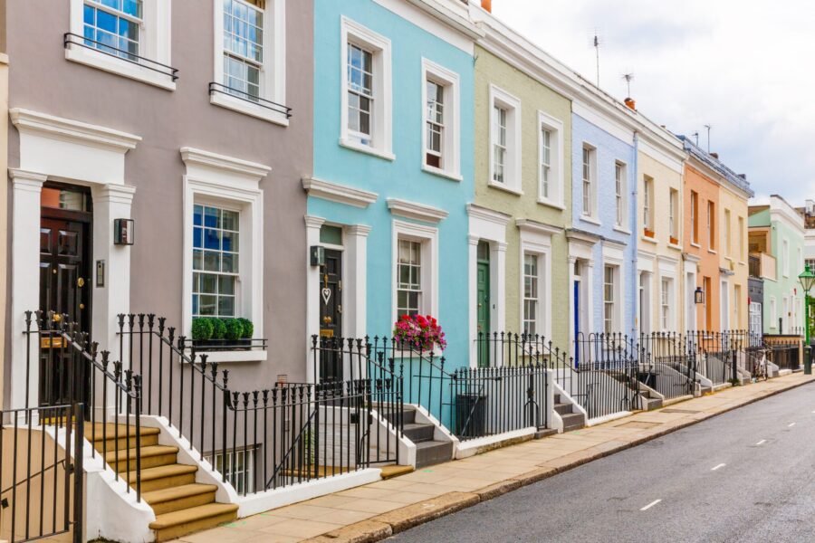 A row of colorful pastel townhouses along a quiet street