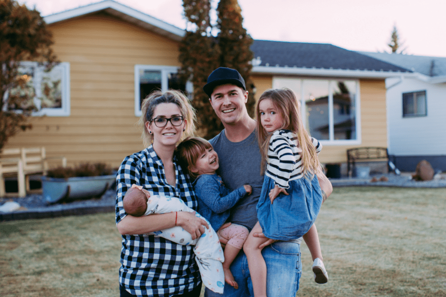 young-family-in-front-of-house