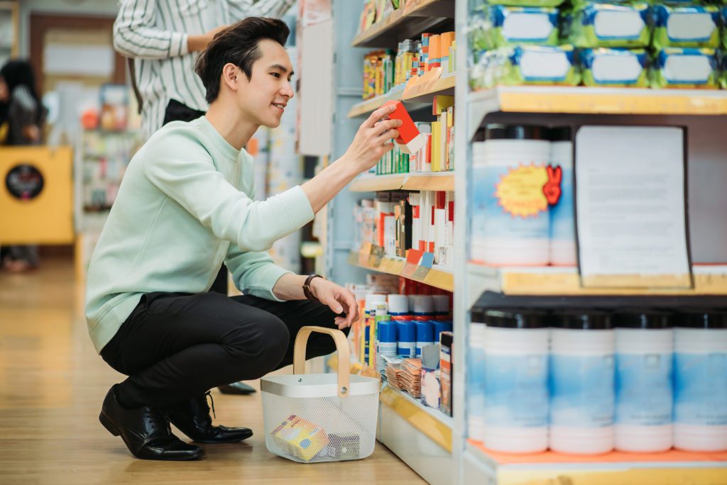 man at supermarket looking to buy pharmaceuticals