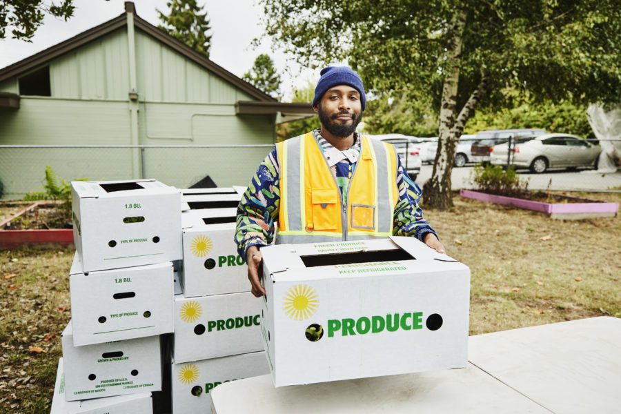 Portrait Of Volunteer At Community Center Giving Away CSA Boxes