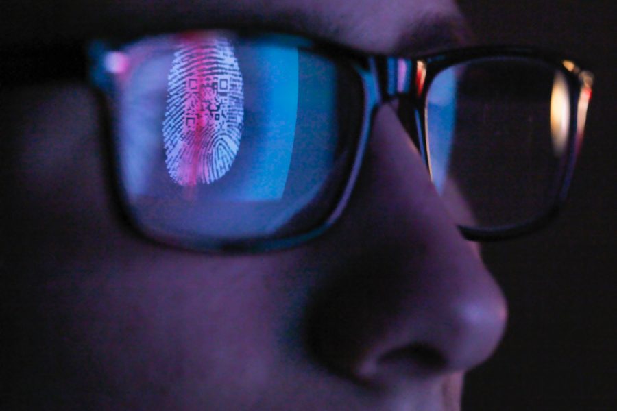 A person wearing glasses with a commercial fingerprint and QR code subtly reflected in the lenses.