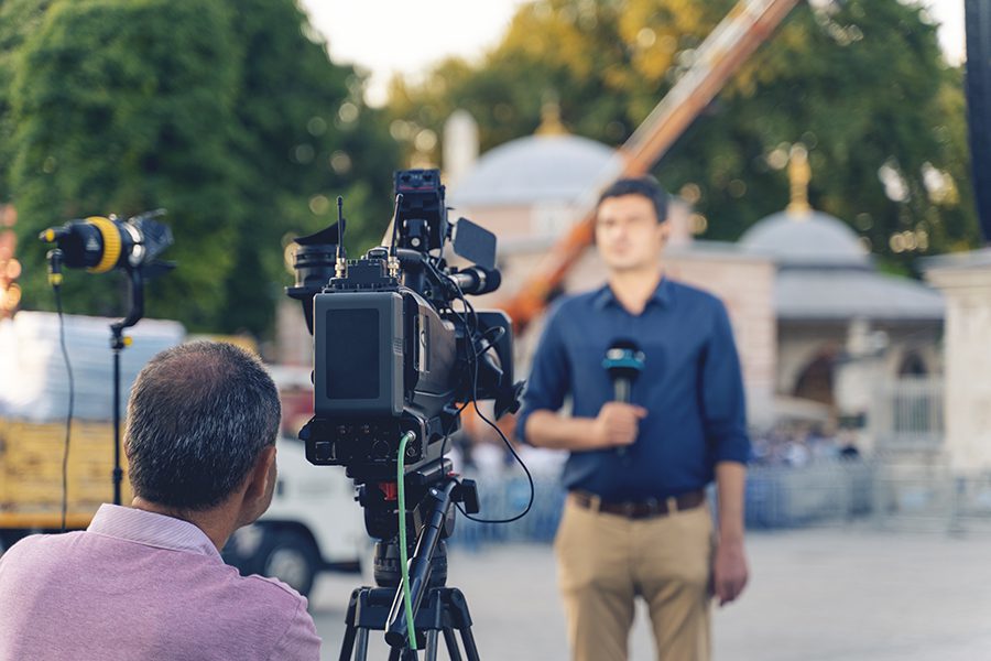 Behind The Scene Concept. Cameraman Working On Professional Camera Taking TV Interviewer, Professional News Reporter Making News Outdoors.