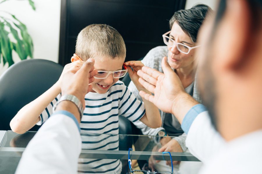 kid-trying-on-glasses-because-of-group-vision-insurance