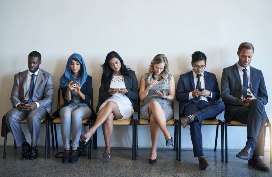 A diverse group of professionals sitting in a row and waiting to be interviewed