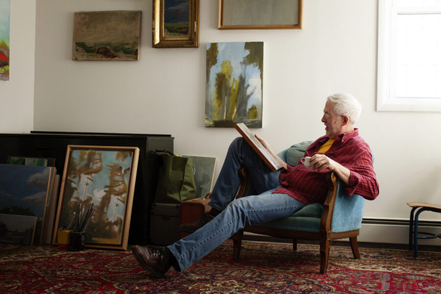 Man Looking At Painting While Sitting On Armchair