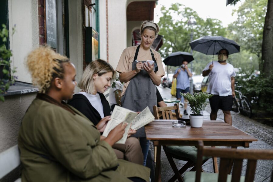 Waitress Taking Customers Orders On Rainy Day