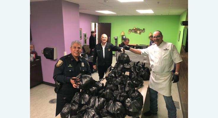 Chef hands bags of food to first responders