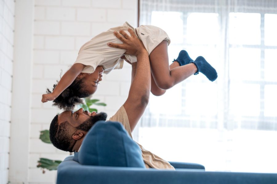 Man playing with daughter at home