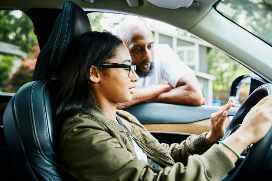 Dad teaching daughter how to drive a car