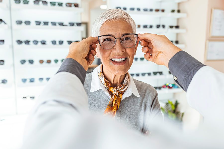 Woman trying on glasses at the eye doctor