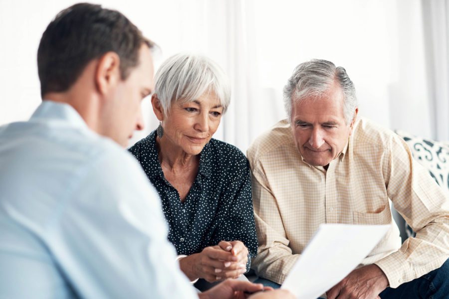 Older couple talking about life insurance options with a broker