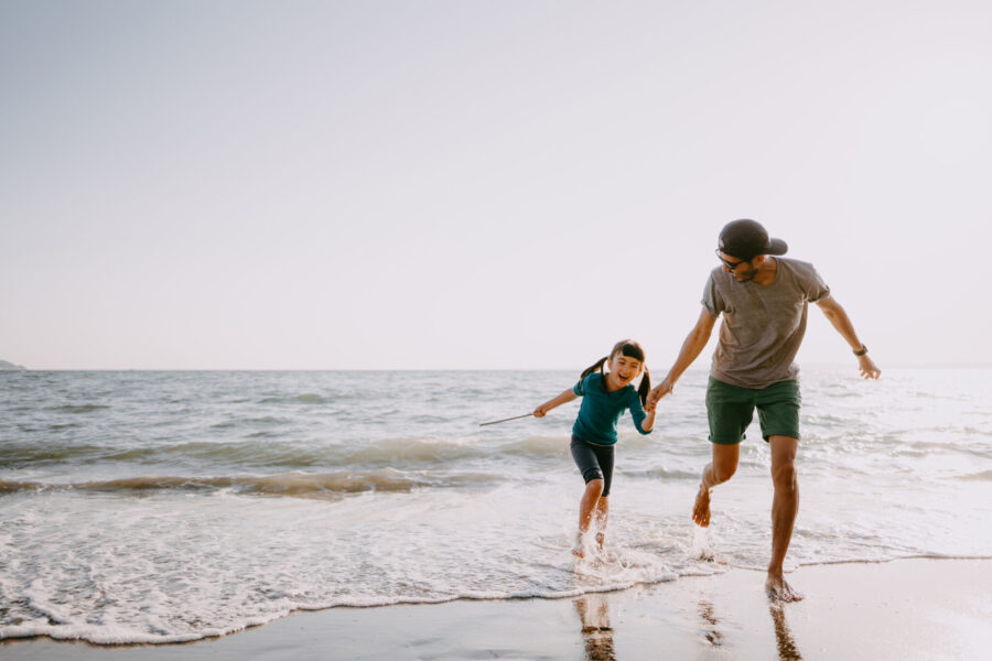Father And Child Running On Beach