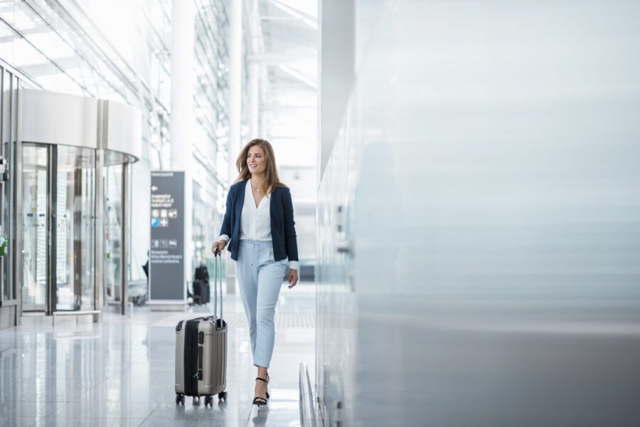 Young businesswoman walking with luggage at the airport