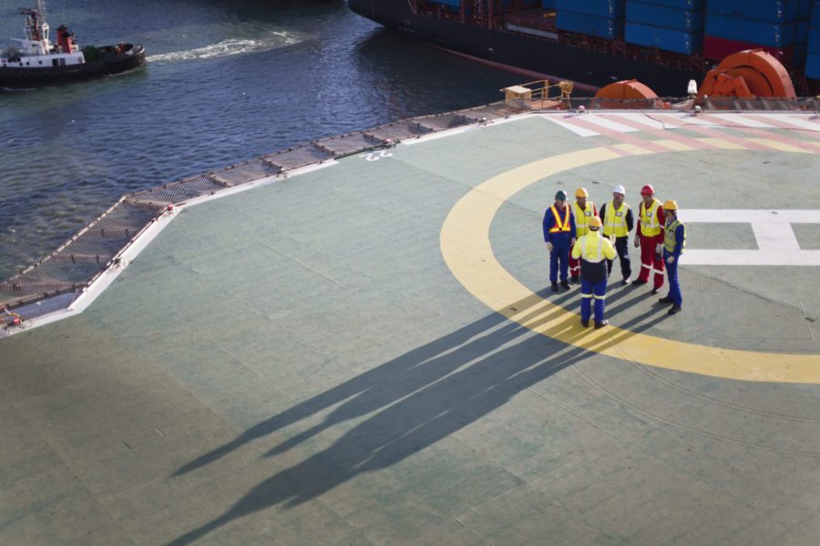 Workers Talking On Helipad Of Oil Rig