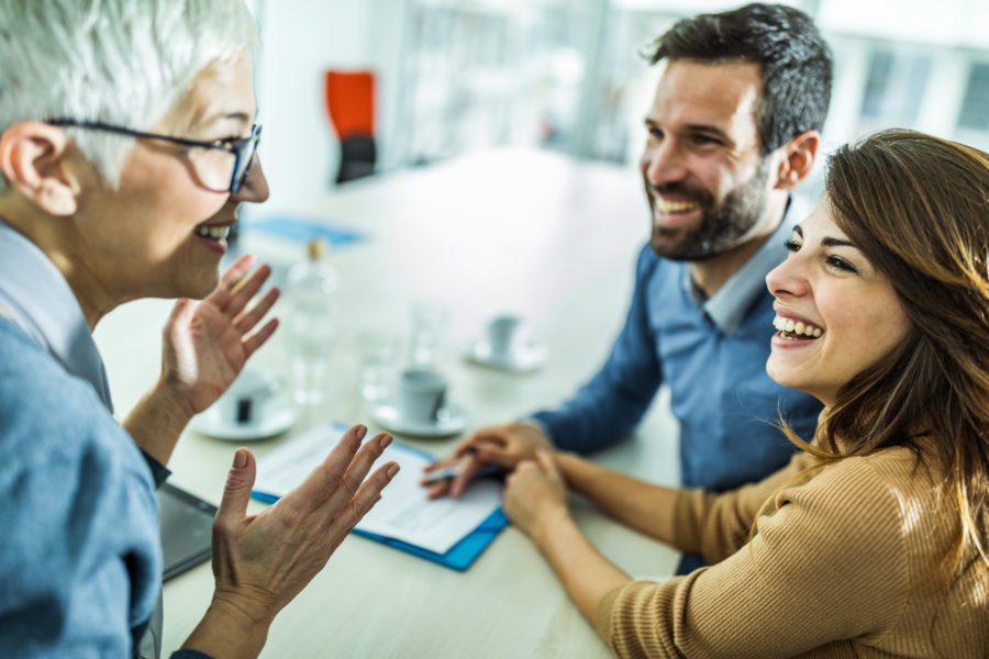 Happy Couple Communicating With Their Financial Advisor On A Meeting In The Office.