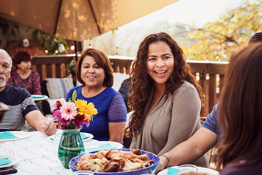 Hispanic Family Laughing At Dinner Table