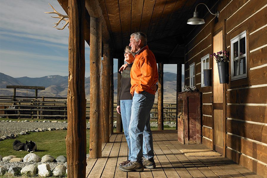 Older Couple Embracing On Cabin Patio