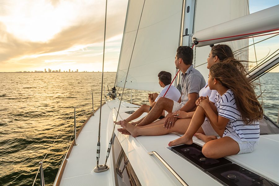 Family On Sailing Boat Looking At Sunset
