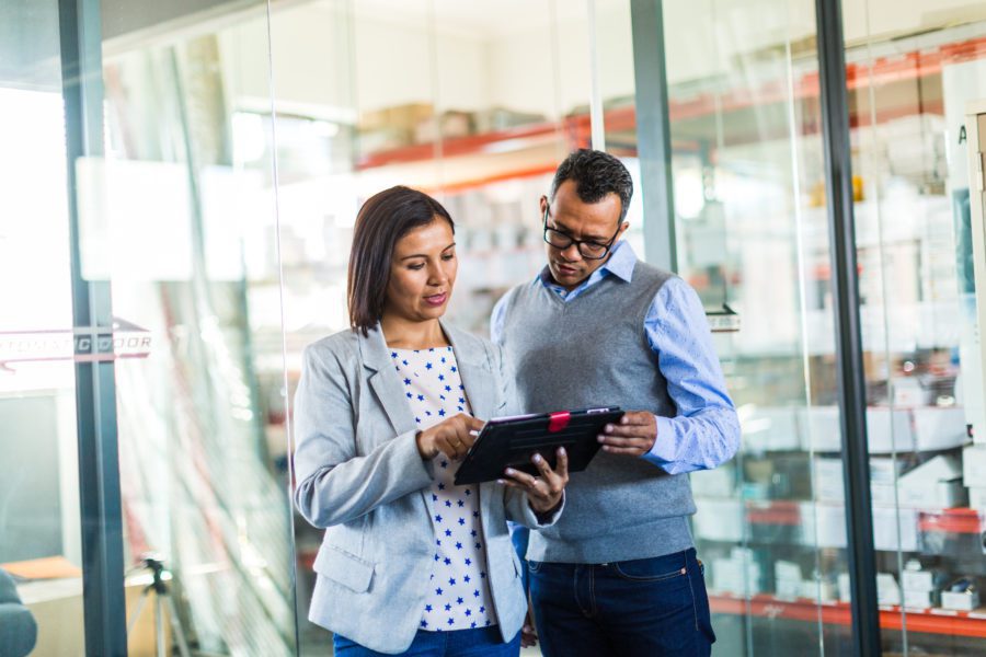 Two professionals reviewing business plans on a tablet in their office