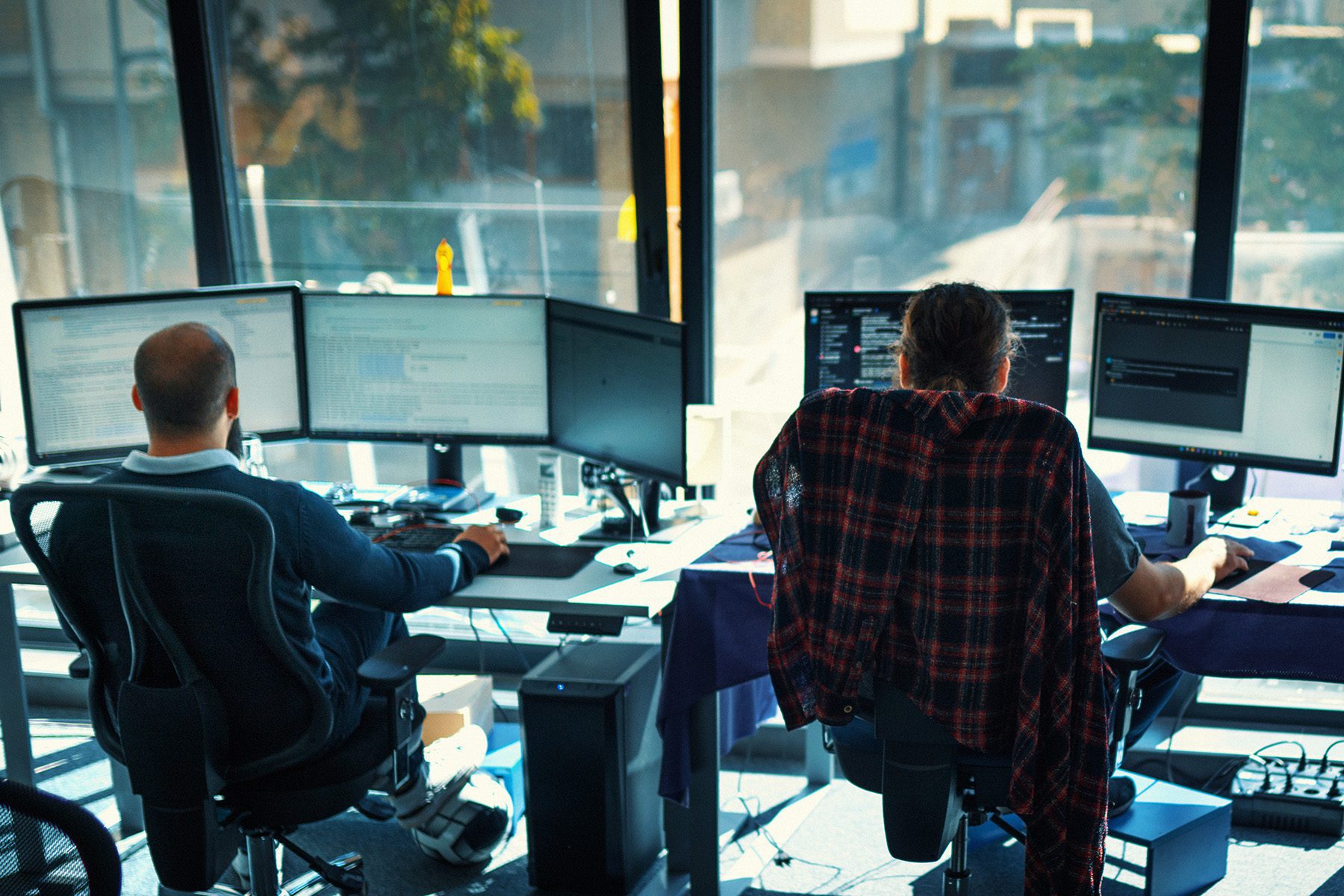 Two software developers coding on their computers