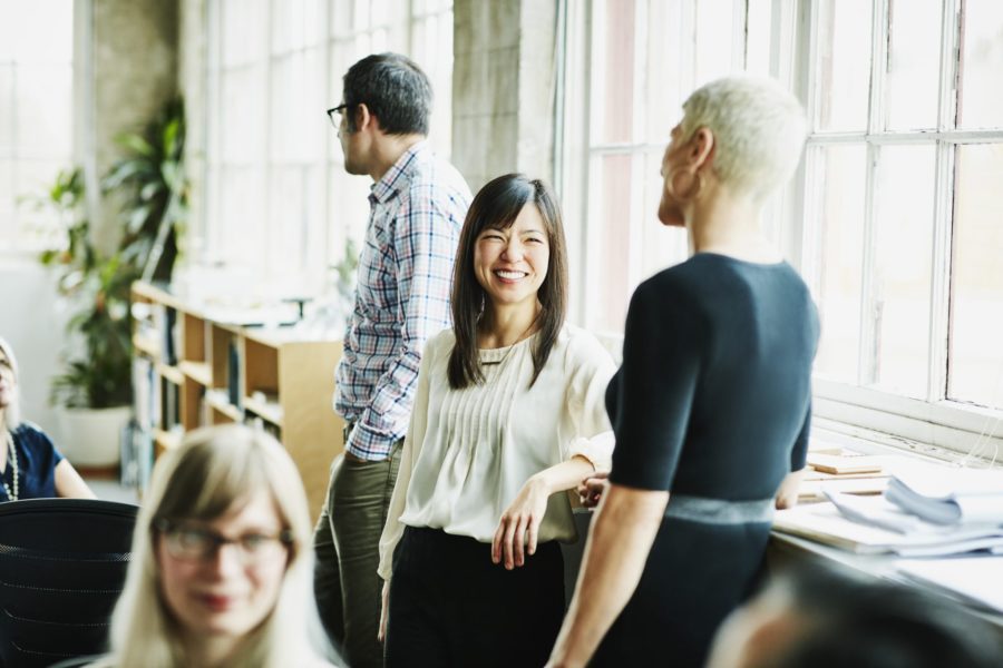 A group of professionals engaged in a business conversation in an office setting