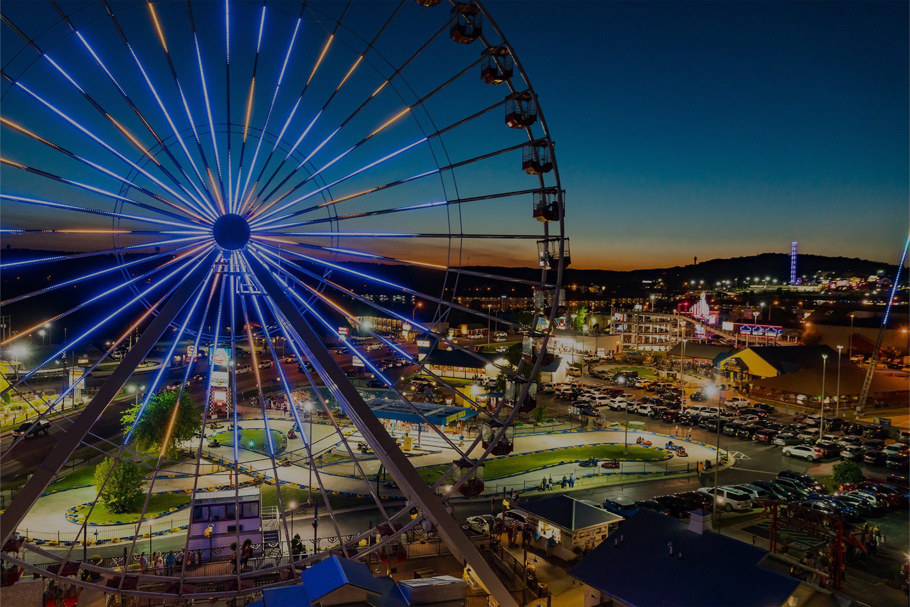 Scenery of a carnival at dusk with the ferris wheel as the main focus