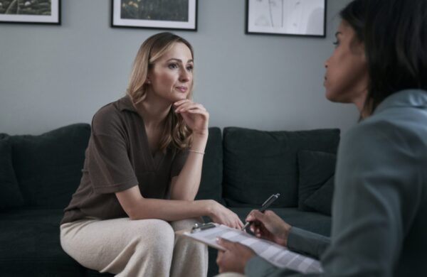Caucasian female patient during the mixed race psychotherapy's visit