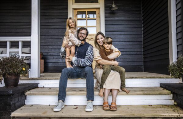 Portrait of young family in front of farmhouse