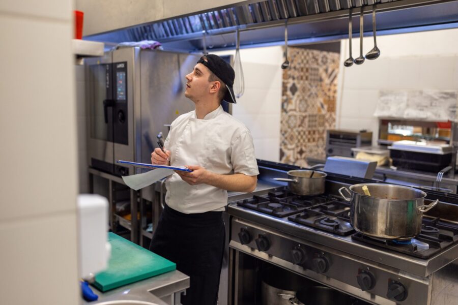 Fast food restaurant male manager doing the inventory int he kitchen