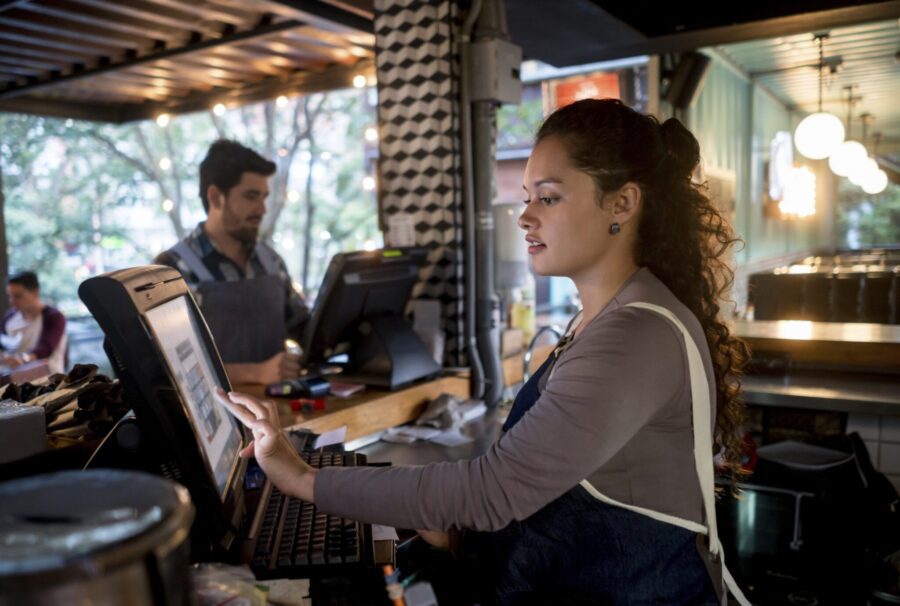 Portrait of a happy woman working at the cashier at a restaurant - food service occupation concepts