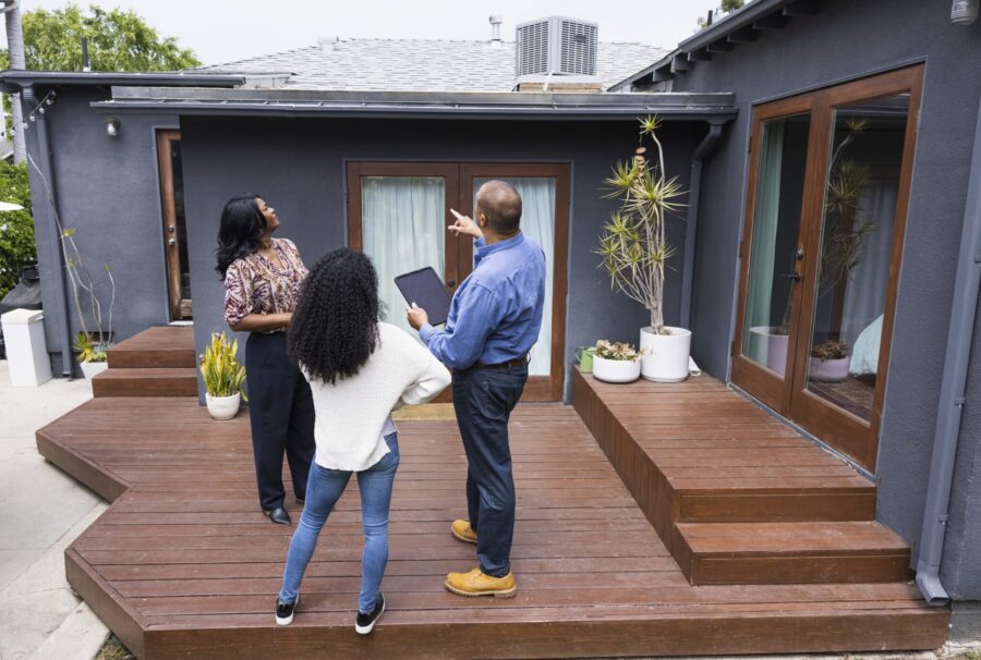 people standing outside looking at home